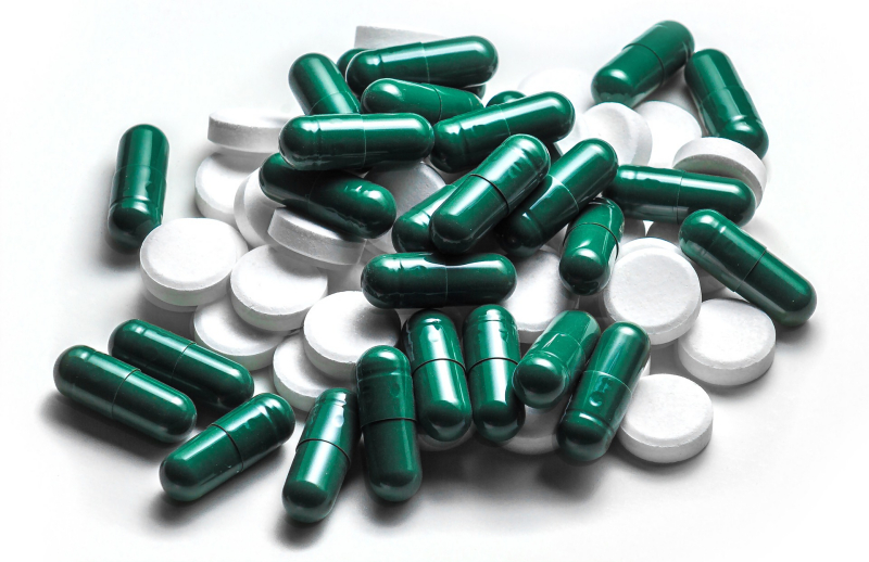 Grüne und weiße Tabletten und Kapseln. Tabletten um Eisenmangel zu bekämpfen